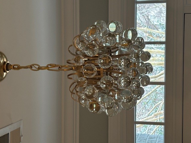 Designer glass bubble chandelier installation in a residential dining space
