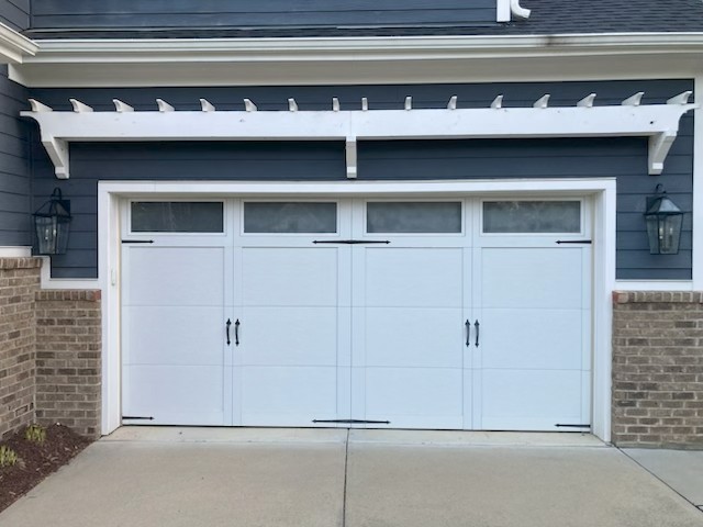 Exterior coach lights installed on garage of residential home