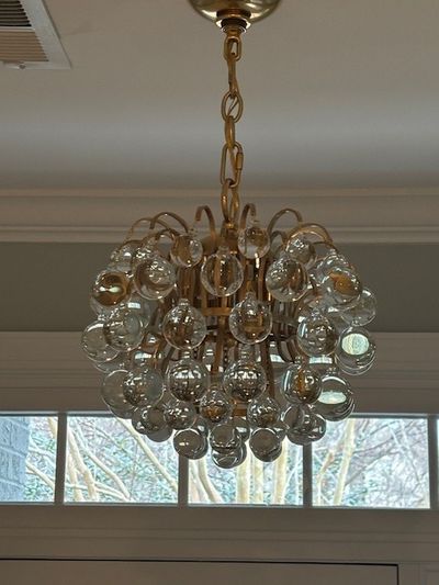 Designer glass bubble chandelier installation in a residential dining space